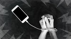Image en noir et blanc de deux mains menottées par le fil de charge d'un Iphone.
